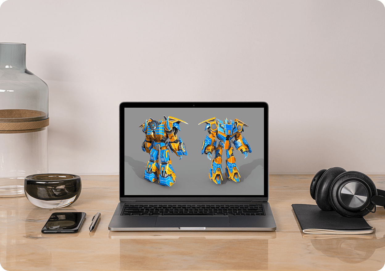 Laptop on wood desk beside headphones showing two robot suit 3D renders