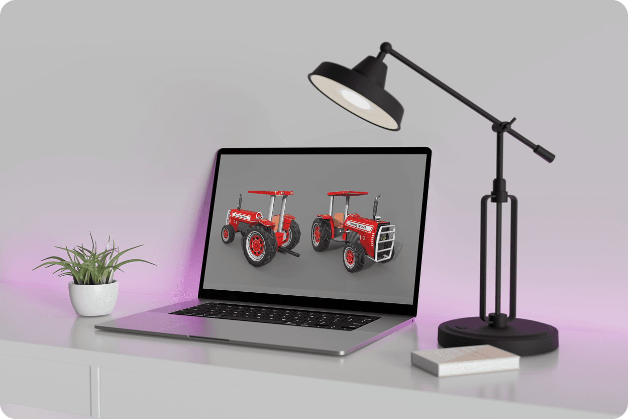 Laptop on purple shelf beside lamp showing two red tractor 3D models