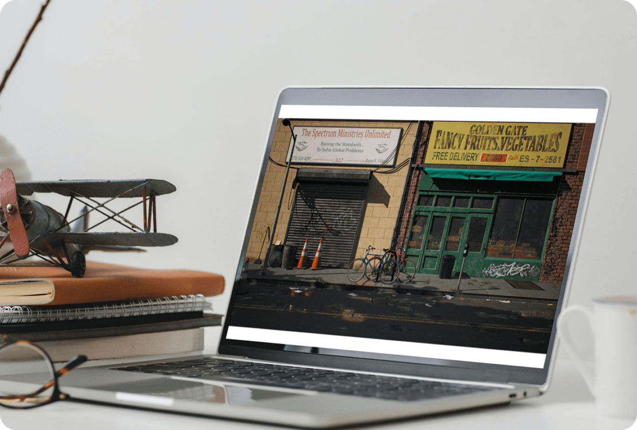 Laptop on grey surface showing yellow wireframe game crate 3D assets