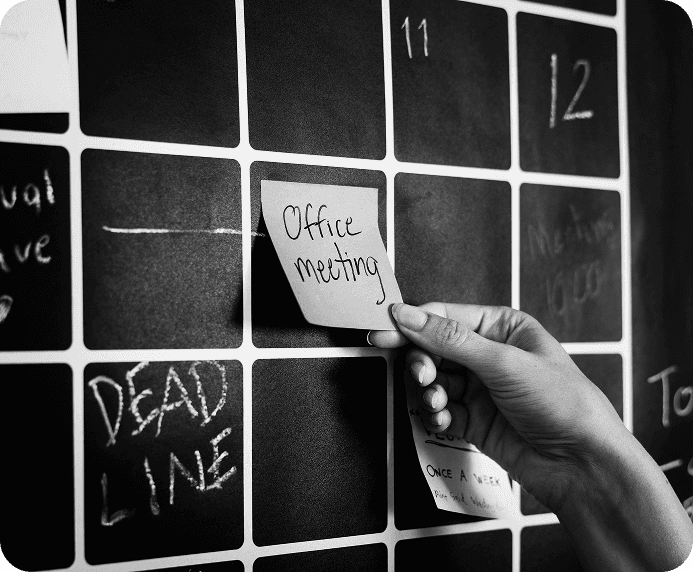 Hand placing a sticky note on a planning board
